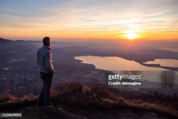 escursionista che guarda il sole all'orizzonte - tramonto foto e immagini stock