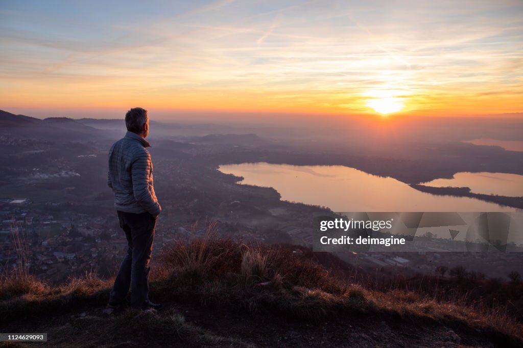 Hiker looking sun over horizon