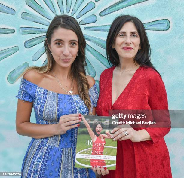 Lauren Francesca and Christine Lusita pose infront of Visual Snow Initiative with her book "The Right Fit Formula" at TAP- Giveback Day on January...