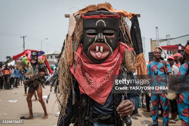 Men in mask perform during a rally of Rivers state's incumbent Governor Ezenwo Nyesom Wike in Port Harcourt, Southern Nigeria, on February 13, 2019....