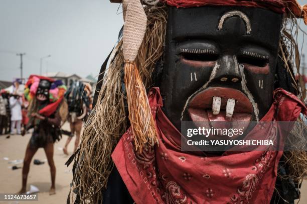 Men in mask perform during a rally of Rivers state's incumbent Governor Ezenwo Nyesom Wike in Port Harcourt, Southern Nigeria, on February 13, 2019....