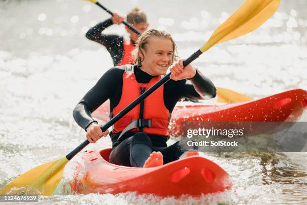 concentrandosi sulla loro corsa in kayak - kayaking foto e immagini stock
