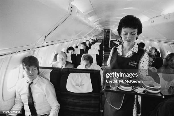 Martine, a flight attendant, serving meals on a British Airways Concorde, UK, 31st August 1983.