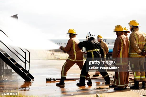 firemen training, firemen spraying water at training facility - international firefighters day stock pictures, royalty-free photos & images