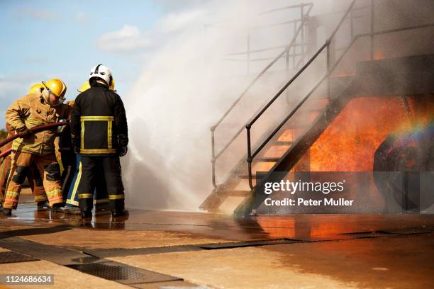 firemen training, firemen spraying water at training facility stairway - international firefighters day stock pictures, royalty-free photos & images