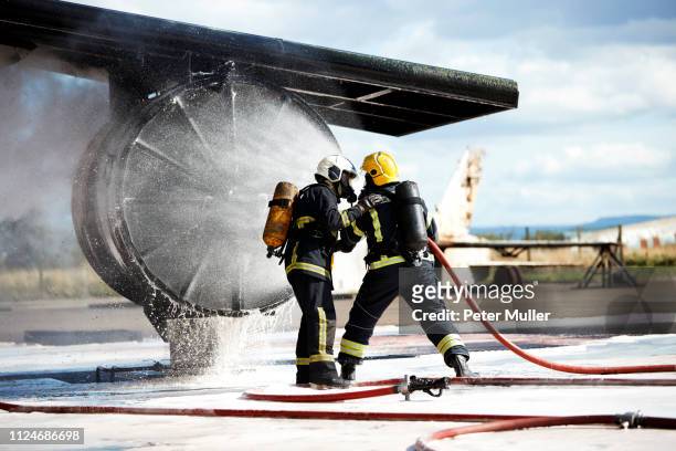 firemen putting out fire on old training aeroplane, darlington, uk - airplane fire stock pictures, royalty-free photos & images