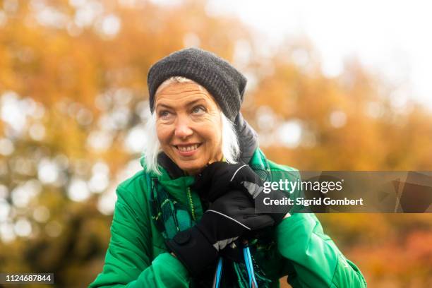 mature woman resting from walk in park - mobility walker stock-fotos und bilder