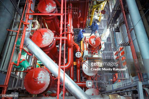 overhead view of engineers in turbine hall of nuclear power station - turbine hall stock pictures, royalty-free photos & images
