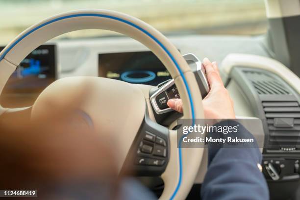 woman pressing start button on electric car - tesla interior stock pictures, royalty-free photos & images