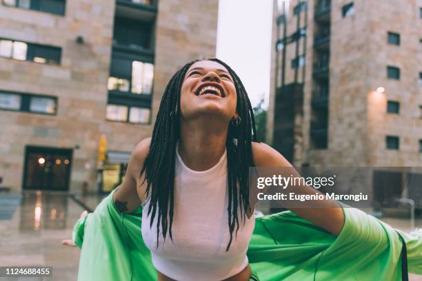 woman welcoming rain in town square, milan, italy - tracksuit jacket stock pictures, royalty-free photos & images