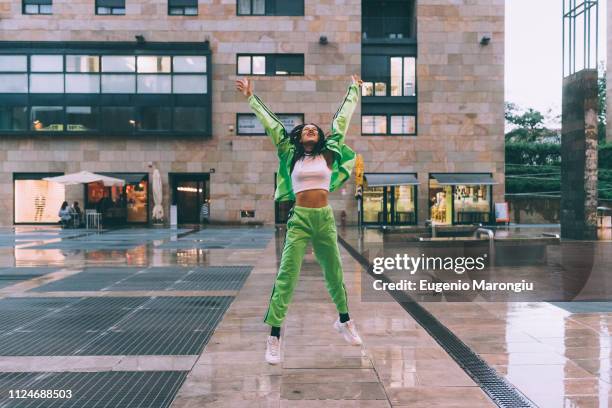 woman welcoming rain in town square, milan, italy - naveltruitje stockfoto's en -beelden