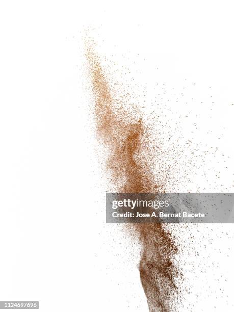 explosion by an impact of a cloud of particles of powder of color brown on a white background. - powder explosion photos et images de collection