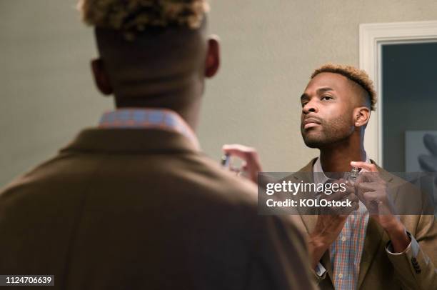 man applying aftershave - man spraying stock pictures, royalty-free photos & images