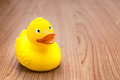 Yellow rubber duck for bath on a wooden table