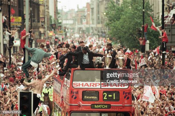 Manchester United celebrate winning the treble as the jubilant team make their way through Manchester during an open top bus parade. Teddy Sheringham...