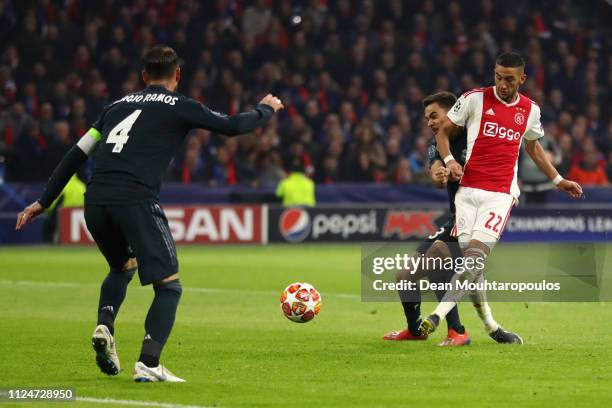 Hakim Ziyech of Ajax scores his team's first goal as Sergio Ramos of Real Madrid attempts to block during the UEFA Champions League Round of 16 First...