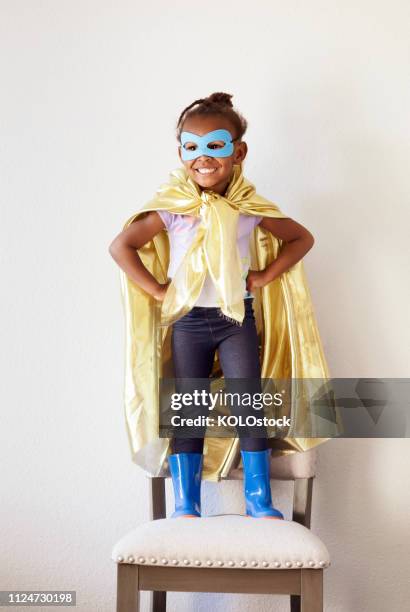 portrait of little girl dressing up as a superhero - zwarte mantel stockfoto's en -beelden