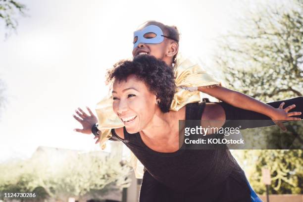little girl playing dressing up with her mother - superhero girl stock pictures, royalty-free photos & images