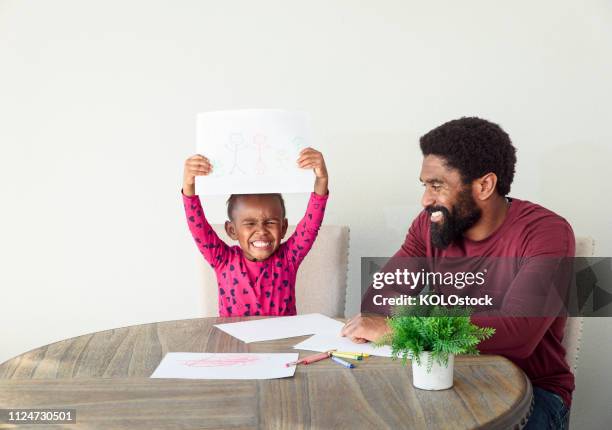 father helping daughter with drawing - holding above head stock pictures, royalty-free photos & images