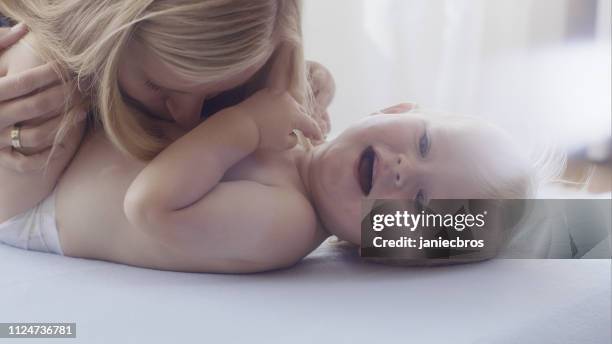 mother playing with her cheering baby - son massage mom stock pictures, royalty-free photos & images