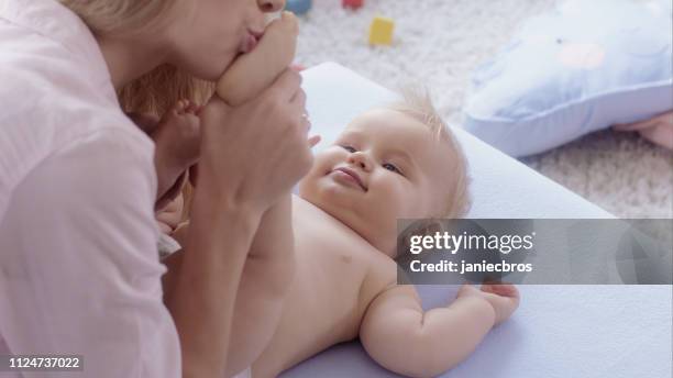 mother kissing baby's feet. close-up - kissing feet stock pictures, royalty-free photos & images