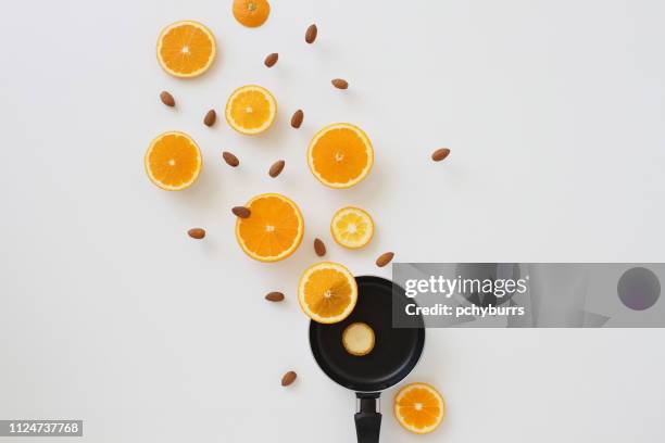 orange slices and almonds flying out of a frying pan - fruit pot stock pictures, royalty-free photos & images