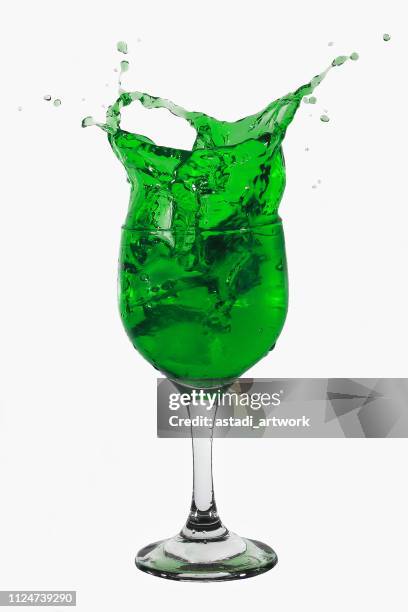 green liquid splashing out of a glass - overflowing glass stock-fotos und bilder