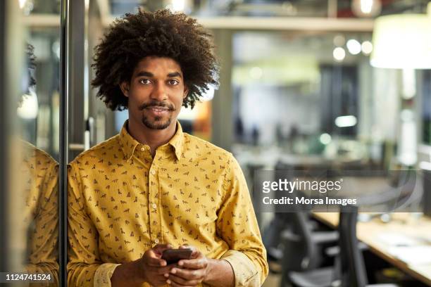 confident businessman with mobile phone in office - african american businessman stock pictures, royalty-free photos & images