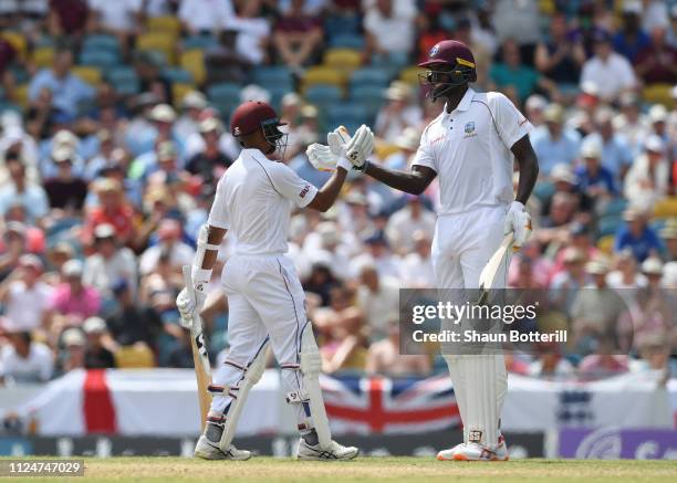 West Indies captain Jason Holder congratulates Shane Dowrich of West Indies on reaching 50 during Day Three of the First Test match between England...