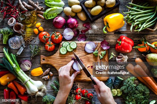 cutting fresh vegetables on rustic wooden table - chopping food stock pictures, royalty-free photos & images