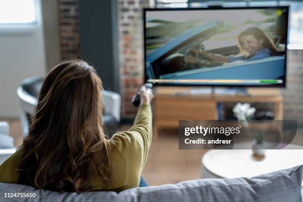 woman relaxing at home watching tv - changing channels stock pictures, royalty-free photos & images