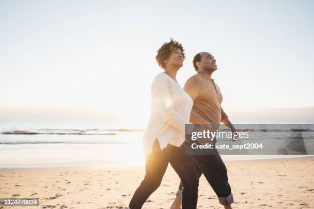 dating after 60 - couple running on beach stock pictures, royalty-free photos & images