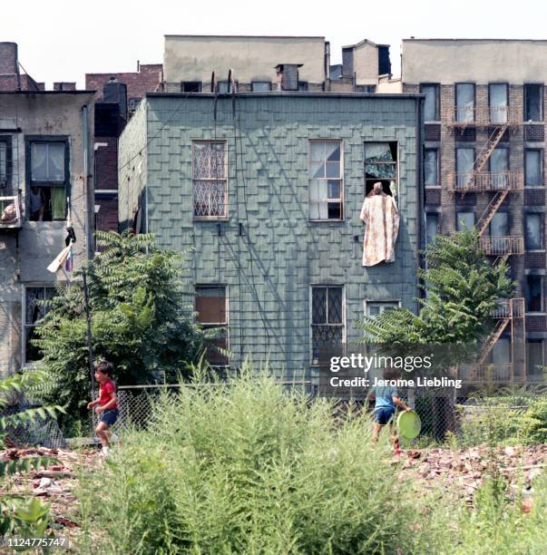 Two unidentified children play in a vacant lot amidst brick rubble of a razed apartment building in New York City's impoverished South Bronx...