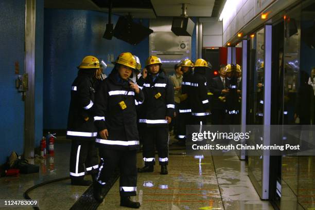 Firemen inspect a damaged MTR compartment in the Admiralty station after a rush-hour arson attack, which injured 14 passengers, in the morning. An...