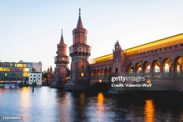 oberbaum bridge with underground between kreuzberg and friedrichshain at sunset, spree, berlin, germany - oberbaumbruecke stock pictures, royalty-free photos & images