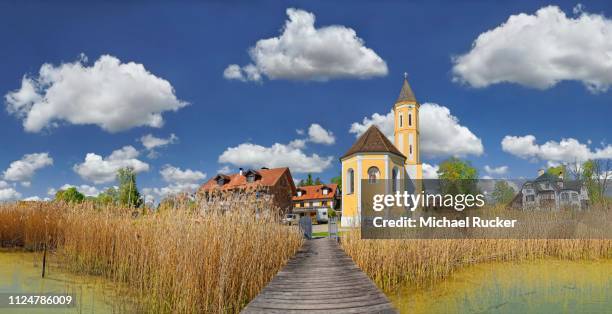 reed-covered shore at the lake ammer and the sant alban church with white blue sky, diessen, lake ammer, bavaria, germany - ammersee stock pictures, royalty-free photos & images