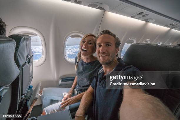 ungt par i flykt tar selfie porträtt glada att åka på semester - ekonomiklass bildbanksfoton och bilder