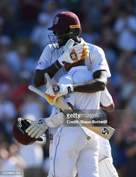 Shane Dowrich of West Indies is congratulated by captain Jason Holder after reaching his 100 during Day Three of the First Test match between England...