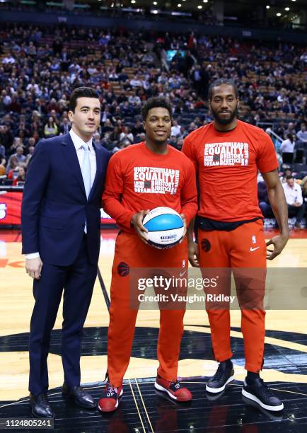 General Manager of the Toronto Raptors Bobby Webster presents an All-Star ball to Kyle Lowry and Kawhi Leonard prior to an NBA game against the...