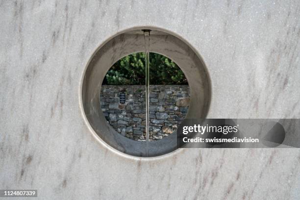 modern architectural fountain outside the church of saint giovanni battista from mogno in valle maggia, ticino, switzerland - little chapel stock pictures, royalty-free photos & images