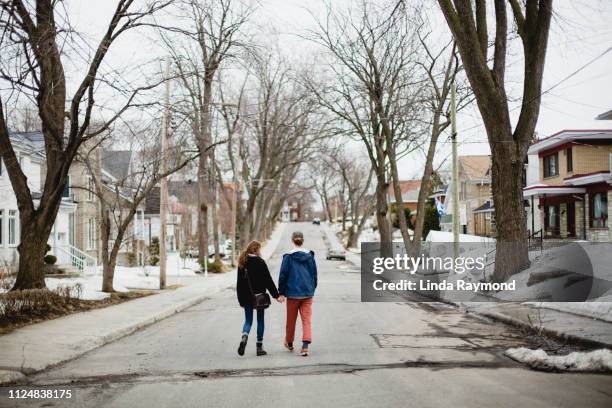 teenage couple walking in the middle of the street - montreal street stock pictures, royalty-free photos & images