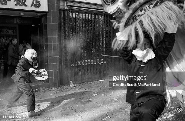 Performers, one in a mask and another as the head of a traditional lion, dance for prosperity and good luck during the annual Chinese New Year...