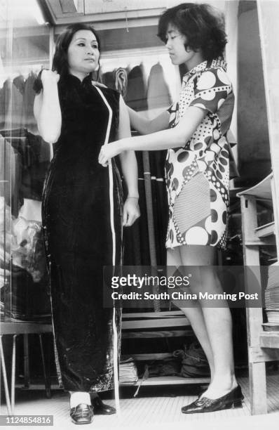 Saleslady measures the length of the cheongsam for a customer in a tailoring shop. 22 May 1971