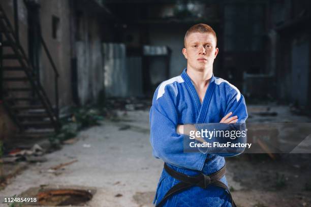 disciplinado practicante de judo con un kimono azul - mens judo fotografías e imágenes de stock