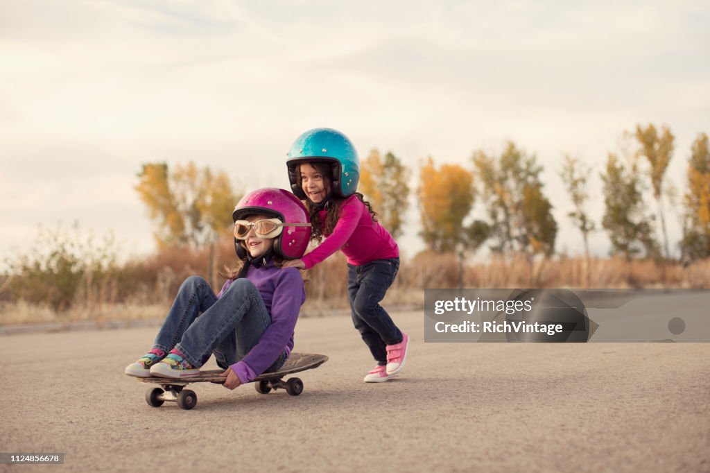 Twee meisjes racen op een Skateboard