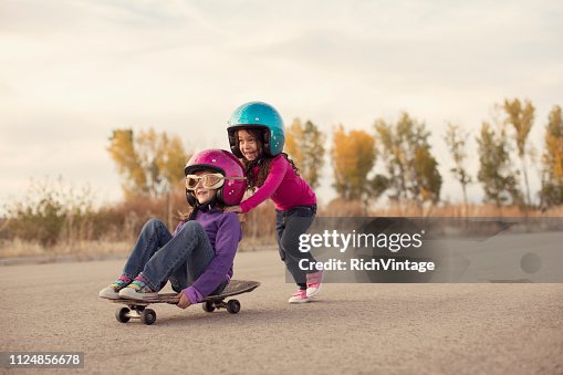 Two Girls Racing on a Skateboard Two Girls Racing on a Skateboard