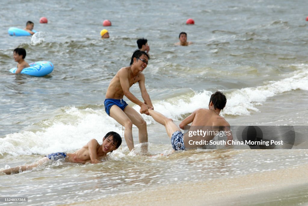 Two guys playing on a beach in Dameisha, Shenzhen East. 09 August 2004