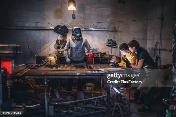 father and two daughters in a metal shop - welding shop stock pictures, royalty-free photos & images