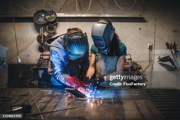 dochter leren de kunst van het lassen van vader - last stockfoto's en -beelden