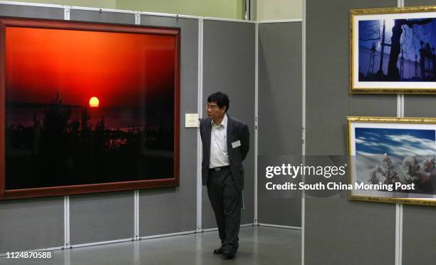 Guest admires the photographs displayed during the opening of the 'Rendezvous with Nature"' photographs by Daisaku Ikeda 'Enjoying Peace of Mind with...